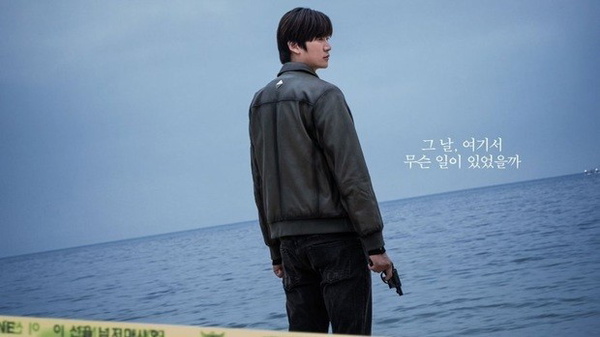 doramas 2023 - Um homem segura um arma de frente para o mar, aparentemente numa área onde um crime aconteceu