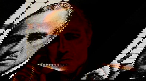 filmes bons para assistir - imagem mostra um homem branco, já meio calvo, sério, vestido formalmente com um terno