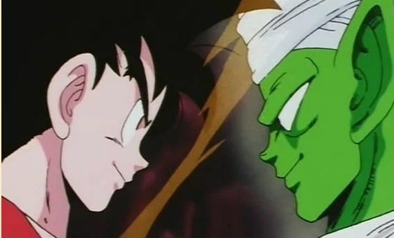 Goku e Piccolo estão frente à frente. A imagem foca nos rostos dos personagens se encarando