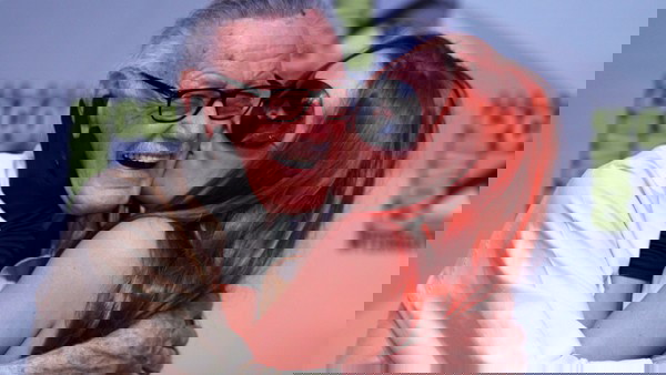 Stan Lee sendo beijado por uma fã